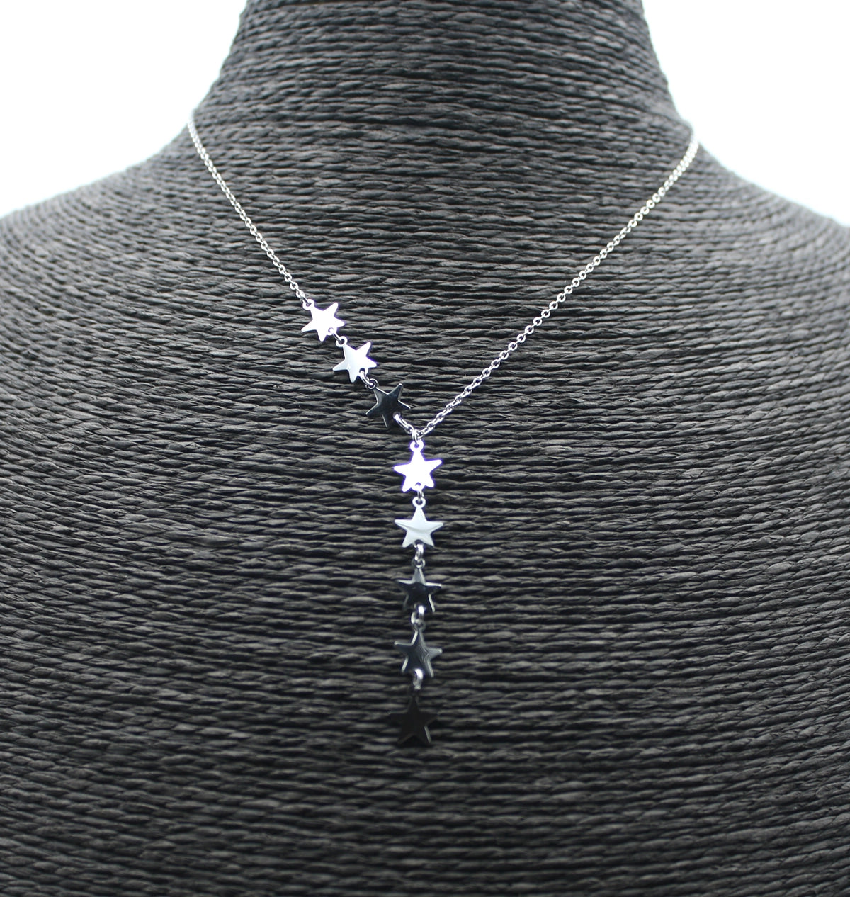 Collar de acero inoxidable plateado con estrellas, presentado sobre busto negro.