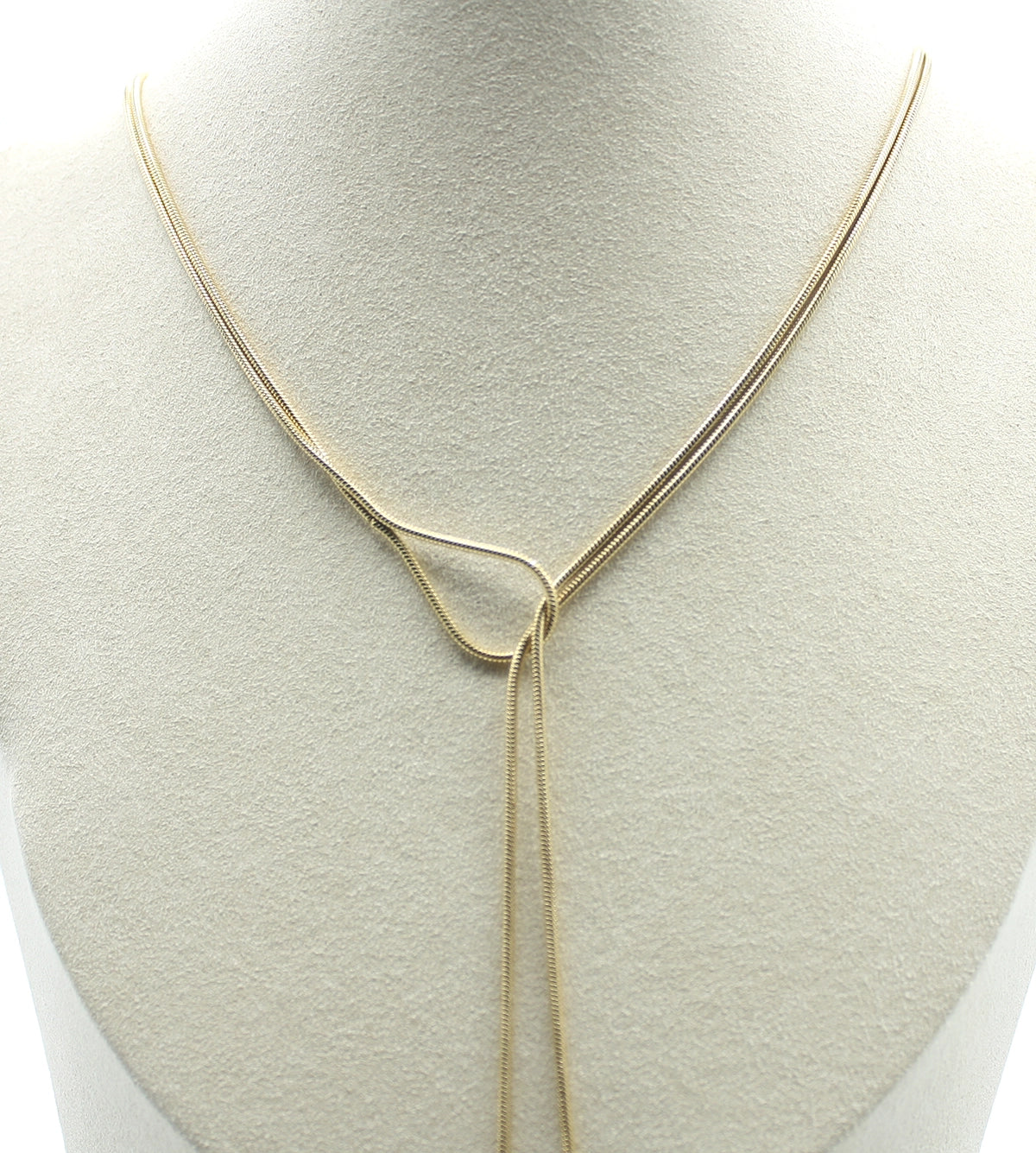 Collar Lazo dorado en busto claro. Acero inoxidable resistente al agua, hipoalergénico y de larga duración. Pieza de diseño de DELACABRA.
