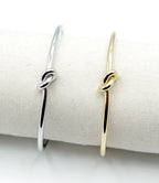 Brazaletes Knot acero inoxidable dorado y plateado en expositor de tela, hipoalérgico liviano y durable - delacabra