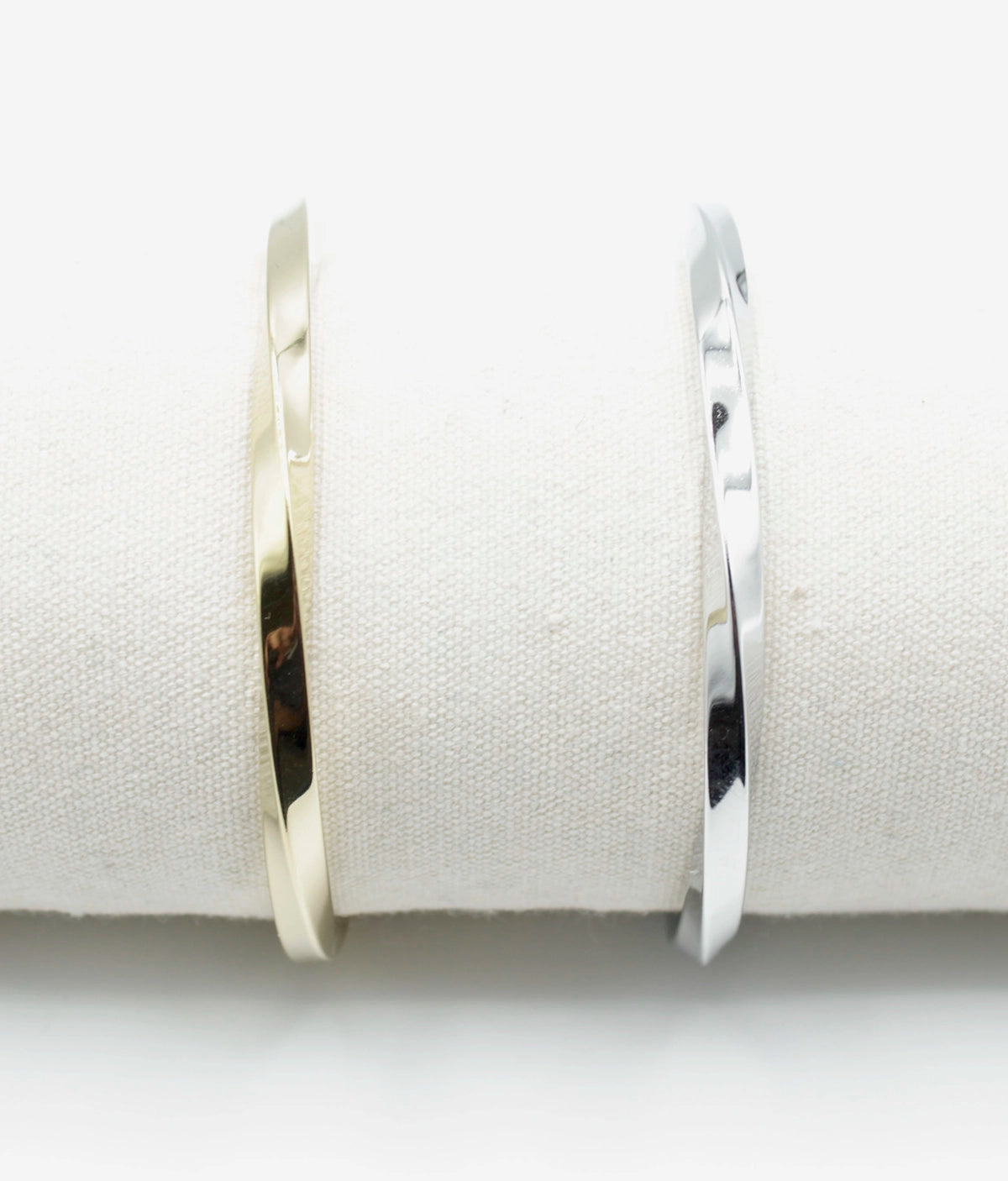 Brazalete Sweet Twist acero inoxidable dorado y plateado en un expositor de tela, diseño robusto y elegante - delacabra
