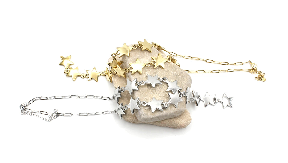 Collares Bella acero inoxidable dorado y plateado, exhibidos encima de una roca, acabado pulido y brillante, eslabones medianos, resistente e hipoalergénico. DELACABRA.COM