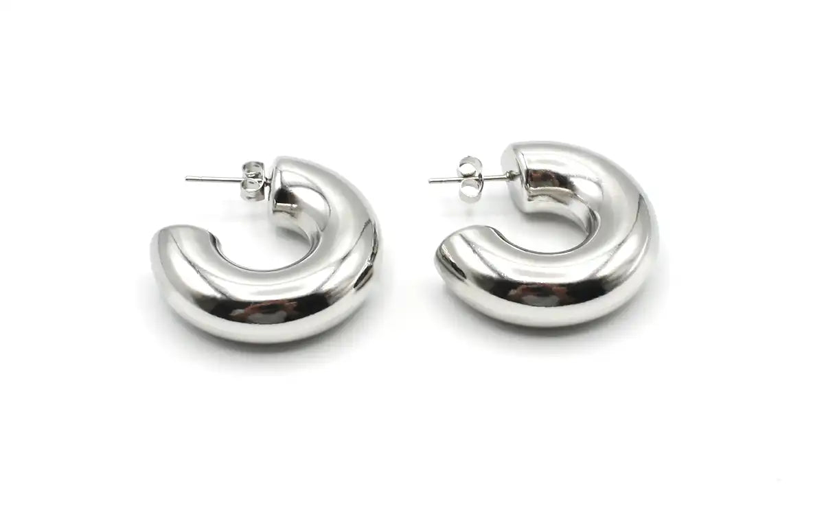 Pendientes aro grandes de acero inoxidable plateado, diseño moderno y grueso sobre fondo blanco.