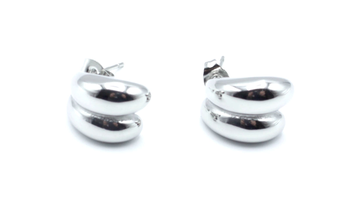 Pendientes Together acero inoxidable plateado con forma suave y redondeada, su acabado pulido y brillante realza el rostro. - DELACABRA