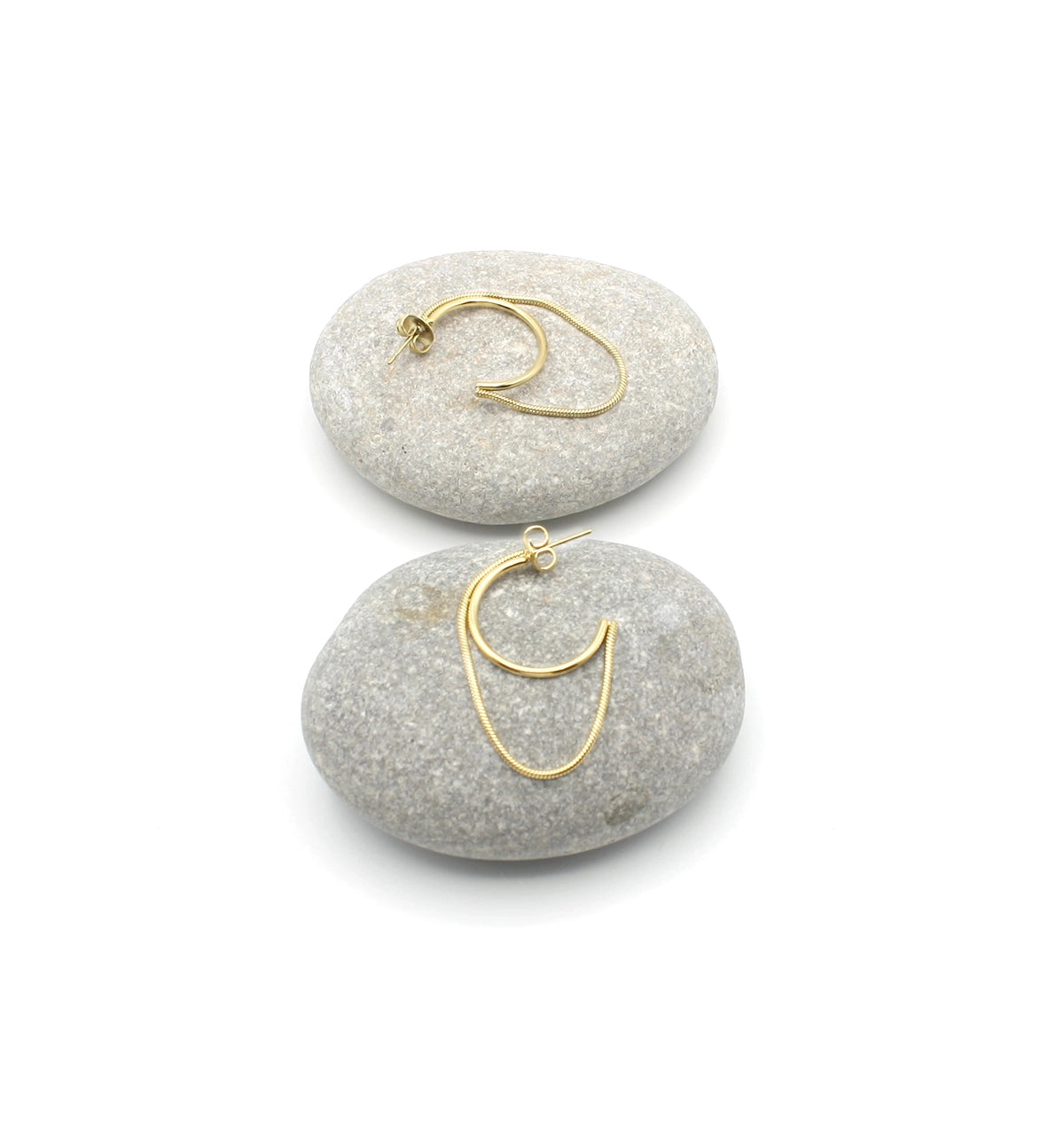 Pendientes Riri acero inoxidable dorado dispuestos en dos rocas, es un aro abierto junto a un lazo dorado que viene unido al aro en cada extremo, un diseño moderno y bellísimo. DELACABRA