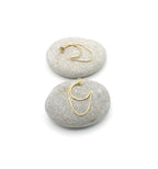 Pendientes Riri acero inoxidable dorado dispuestos en dos rocas, es un aro abierto junto a un lazo dorado que viene unido al aro en cada extremo, un diseño moderno y bellísimo. DELACABRA