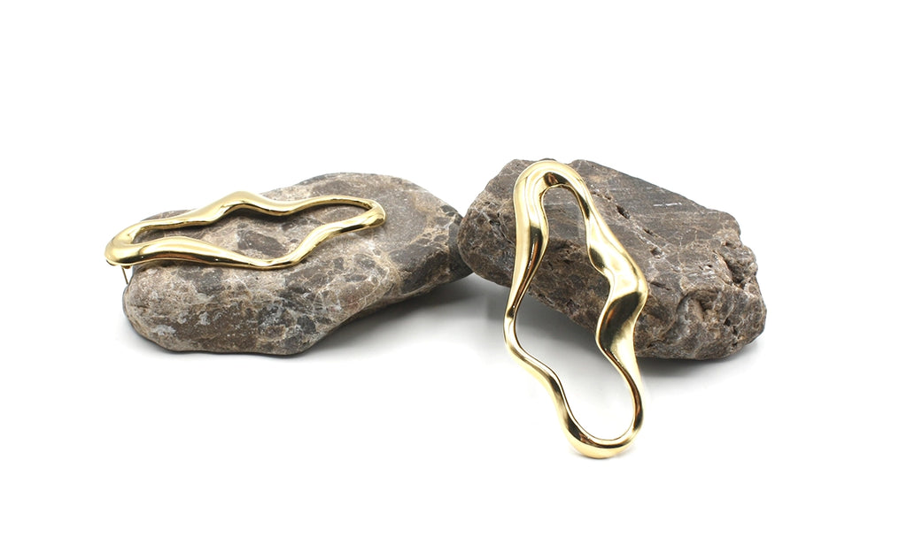 Pendientes Sofía acero inoxidable dorado diseño abstracto de lineas y curvas suaves, alargado, acabado brillante espejo, elegante y versátil. DELACABRA.COM 