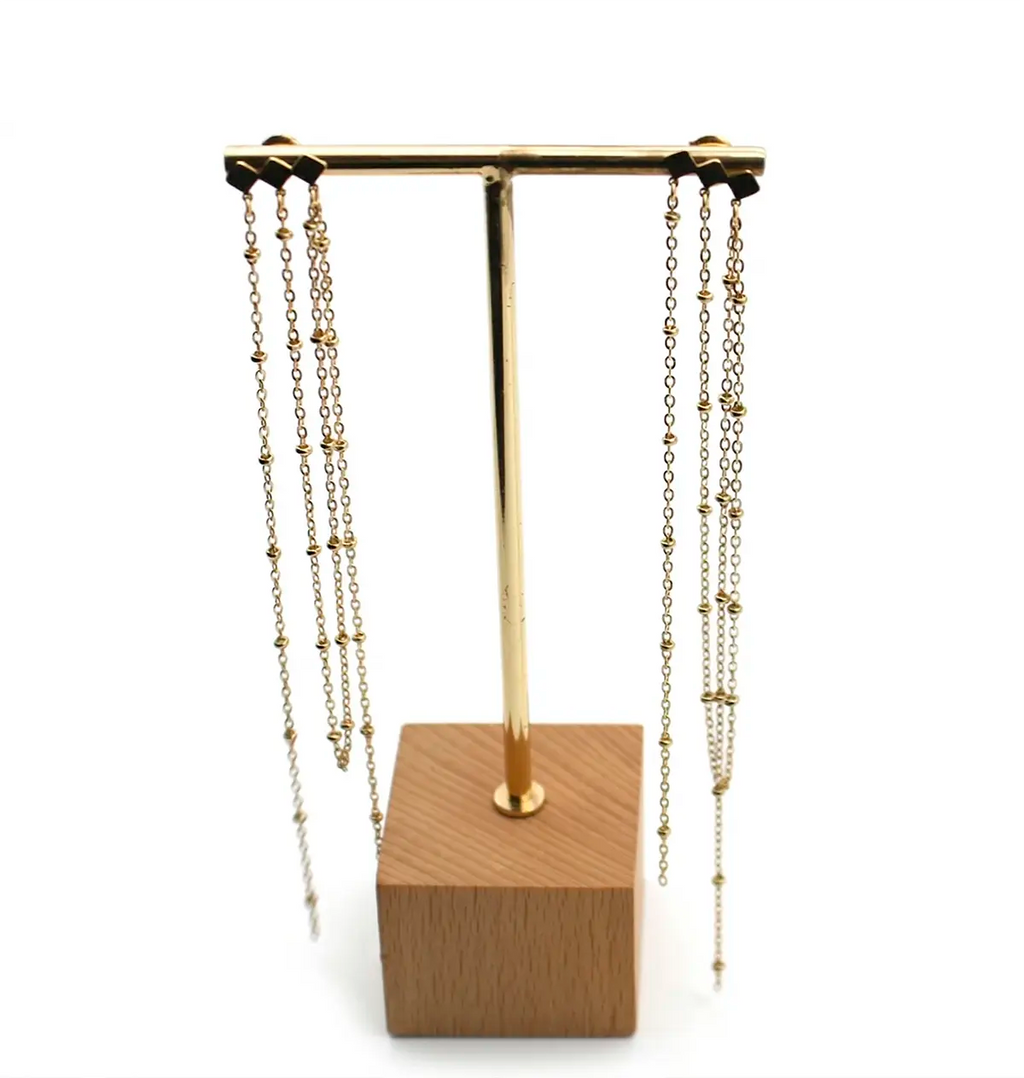 Pendientes largos elixir diseño de una barra con tres rombos de los cuales cuelgan a manera de hilos sendas cadenas. Delacabra