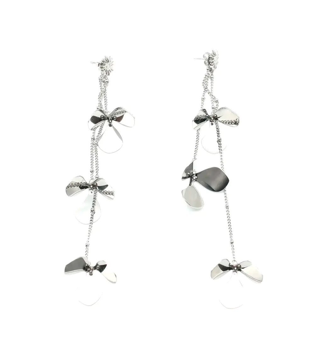 Pendientes plateados Petal Bloom con flores de acero y caída asimétrica. Joyería amable con la piel de DELACABRA.
