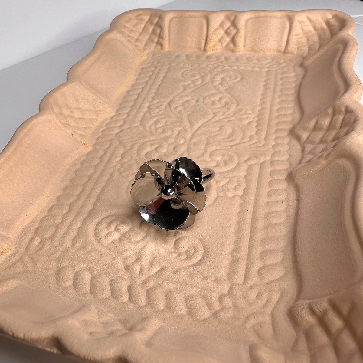 Anillo Colibrí  marca delacabra, acero inoxidable tono plateado, ajustable, discreto y moderno, elegante y forma de flor de varios pétalos