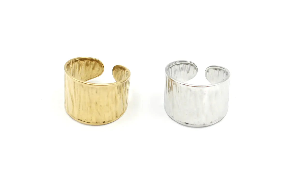 Anillos ajustables de mujer en acero inoxidable, uno dorado y uno plateado, con textura martillada.