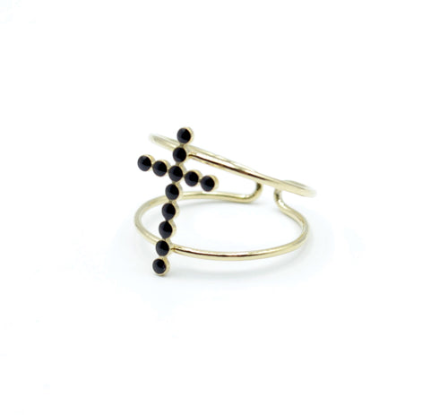 Anillo CROSS MY HEART de DELACABRA en acero inoxidable dorado, diseño ajustable con doble aro y cruz frontal compuesta por pequeñas piedras negras.
