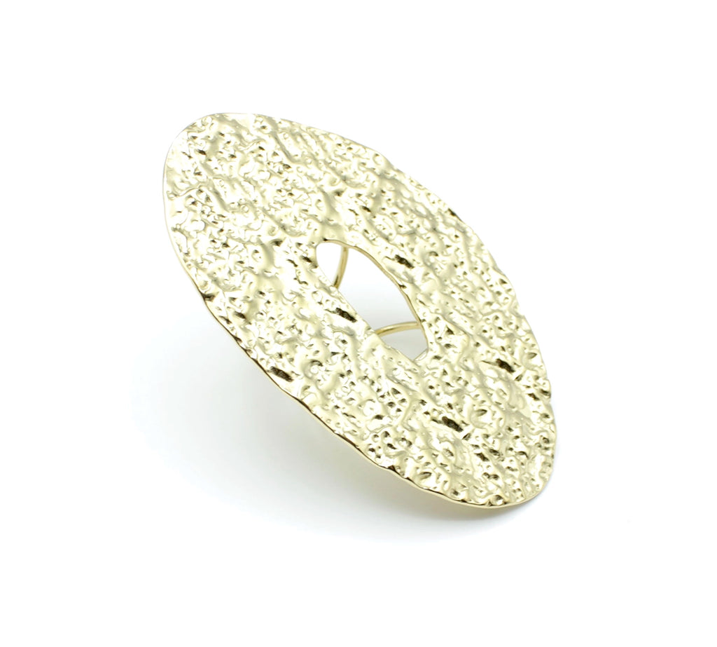 Anillo ajustable GLOOM de DELACABRA en acero inoxidable dorado, con forma ovalada, superficie orgánica martillada y abertura central, vista en ángulo