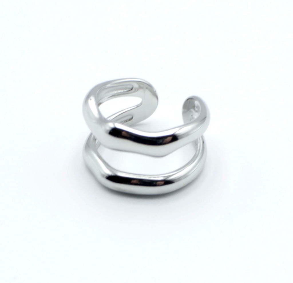 Anillo plateado con dos bandas curvas paralelas, de acero inoxidable brillante, diseño abierto y estructura ajustable.