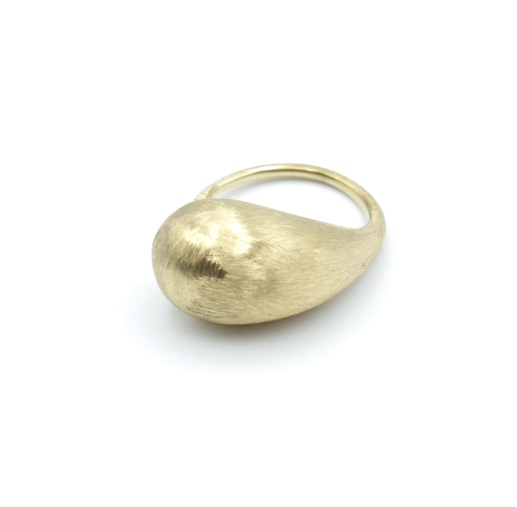 Vista lateral del anillo DROP DELACABRA en acero inoxidable dorado, diseño con forma de gota y acabado mate cepillado, modelo ajustable