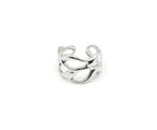 Anillo abierto de acero plateado con curvas fluidas y espacios vacíos. Joya amable con la piel y resistente DELACABRA.