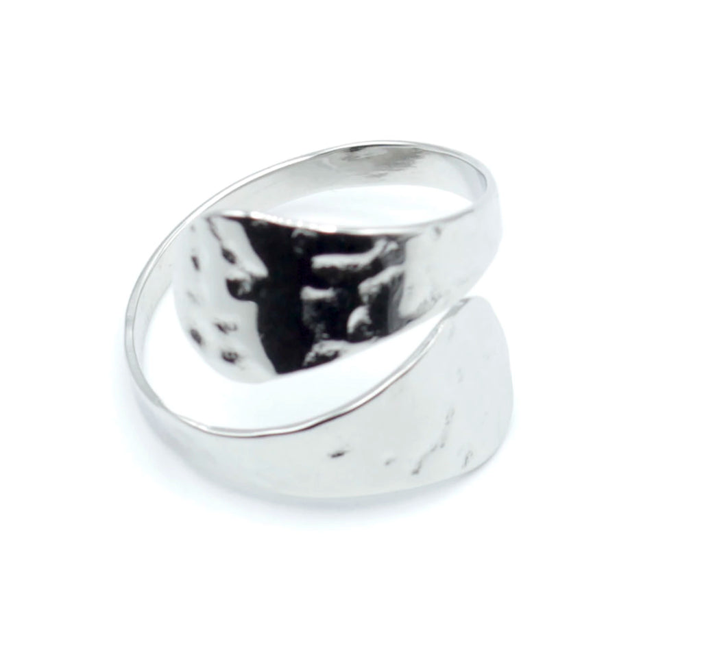 Anillo plateado ajustable de acero inoxidable de la marca DELACABRA con diseño abierto y textura martillada visto desde arriba, hipoalergénico y resistente al agua
