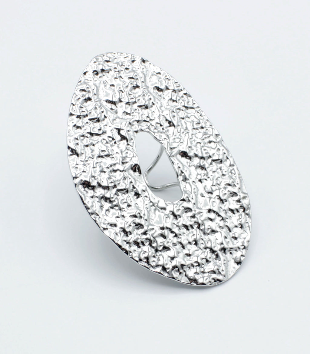 Anillo GLOOM de DELACABRA en acabado plateado, diseño ajustable en acero inoxidable con textura orgánica martillada y forma ovalada con abertura central