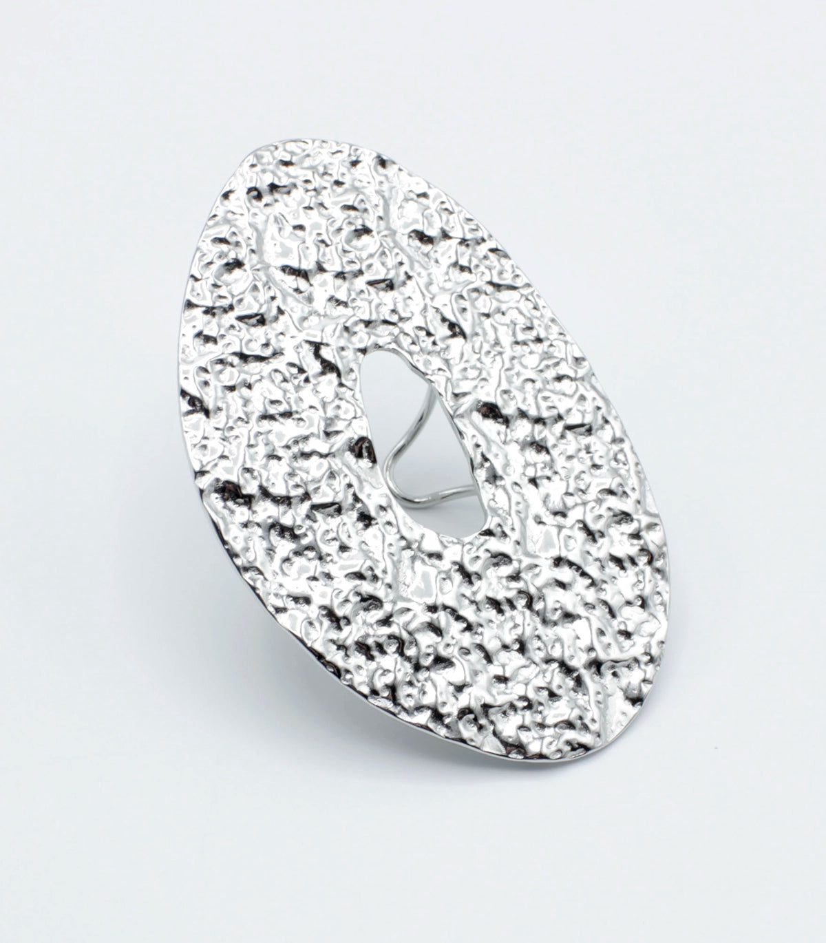 Anillo GLOOM de DELACABRA en acabado plateado, diseño ajustable en acero inoxidable con textura orgánica martillada y forma ovalada con abertura central