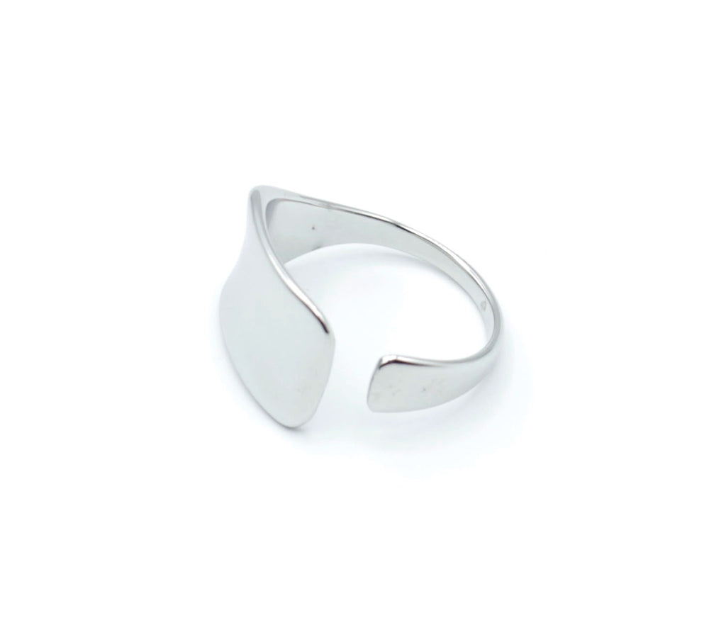 Anillo plateado Jay de acero inoxidable visto desde el lateral, diseño ajustable, forma geométrica suave y acabado pulido, pieza minimalista de Delacabra.