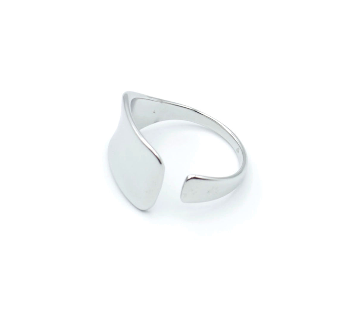 Anillo plateado Jay de acero inoxidable visto desde el lateral, diseño ajustable, forma geométrica suave y acabado pulido, pieza minimalista de Delacabra.