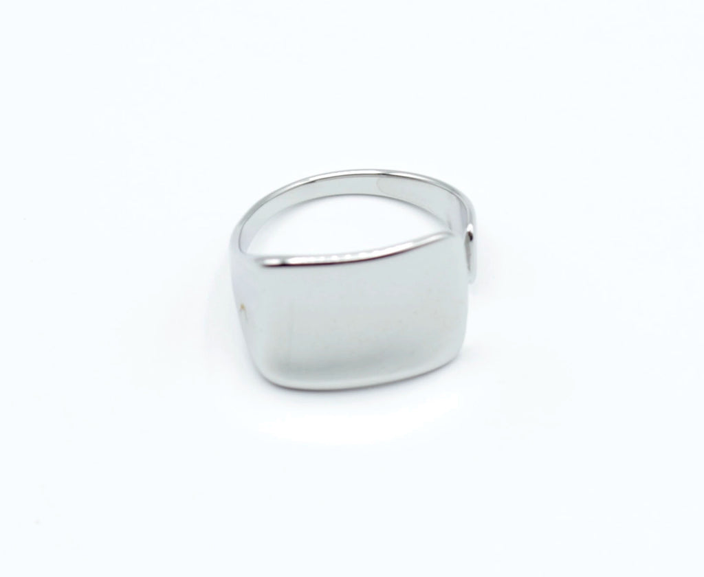 Anillo Jay plateado con forma rectangular curva, diseño liso y elegante de acero inoxidable ajustable, marca Delacabra.