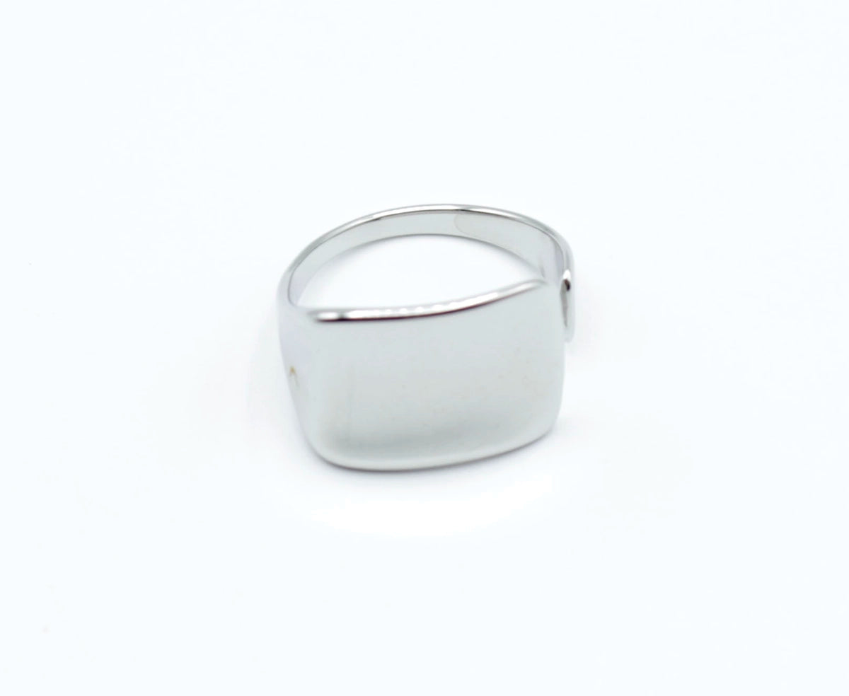 Anillo Jay plateado con forma rectangular curva, diseño liso y elegante de acero inoxidable ajustable, marca Delacabra.