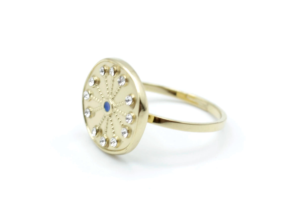 Anillo dorado La Mer con diseño circular decorado con cristales y centro azul, vista lateral elegante