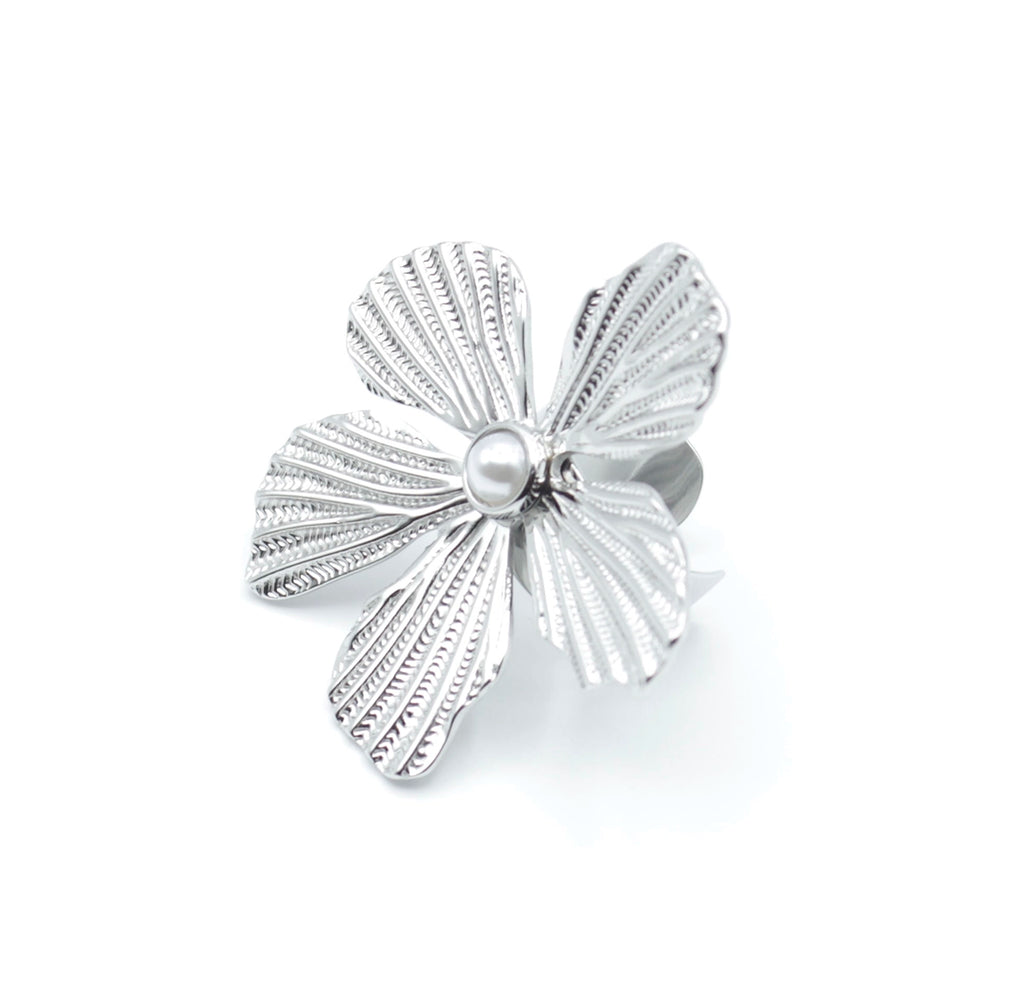 Anillo Lover ajustable en color plateado, con flor en relieve y perla blanca en el centro, diseño elegante de acero inoxidable