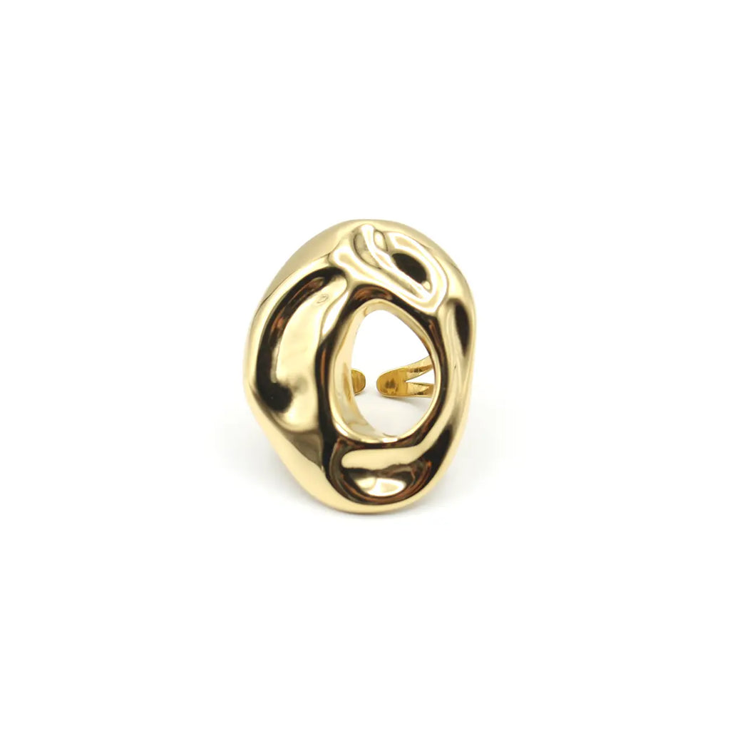 Anillo dorado de forma ovalada con superficie orgánica irregular y hueco central. Acero amable con la piel DELACABRA
