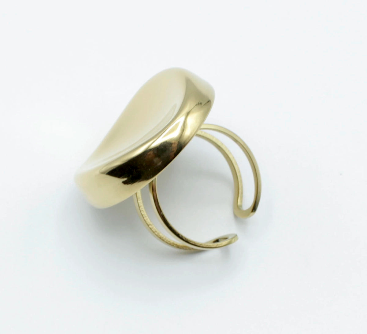 Anillo Zahara dorado ajustable de acero inoxidable visto en ángulo inclinado. Forma ovalada moderna, ideal para uso diario