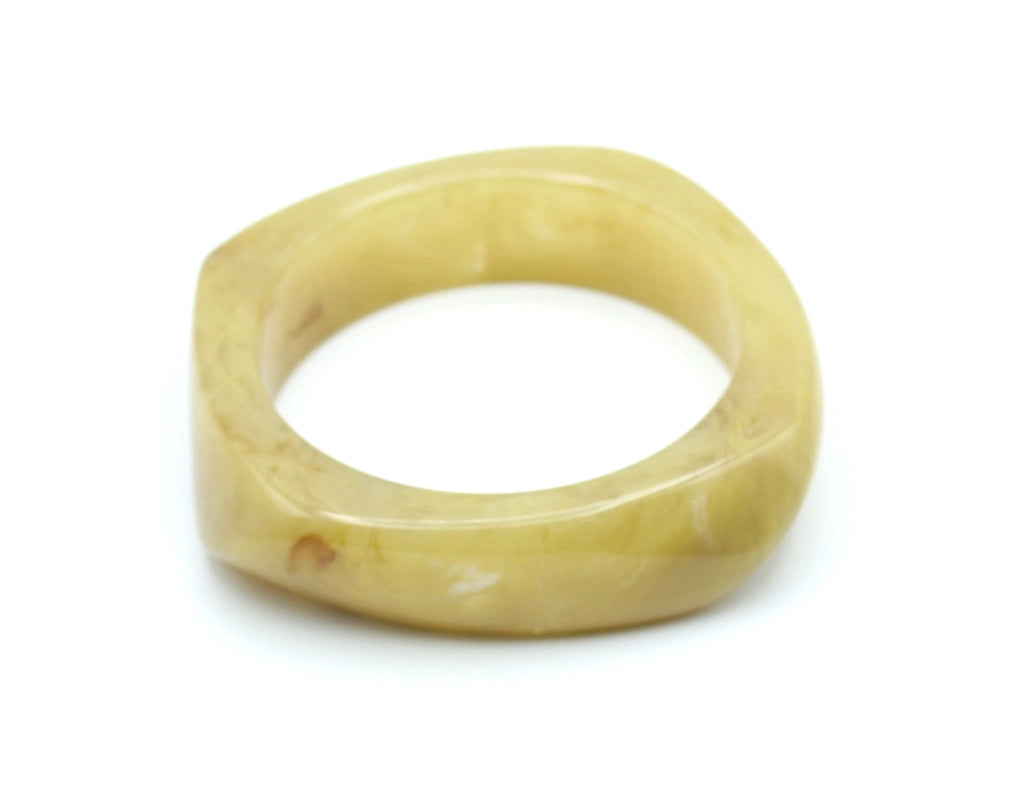 Pulsera Amber en resina color miel con textura suave y diseño geométrico redondeado. - DELACABRA