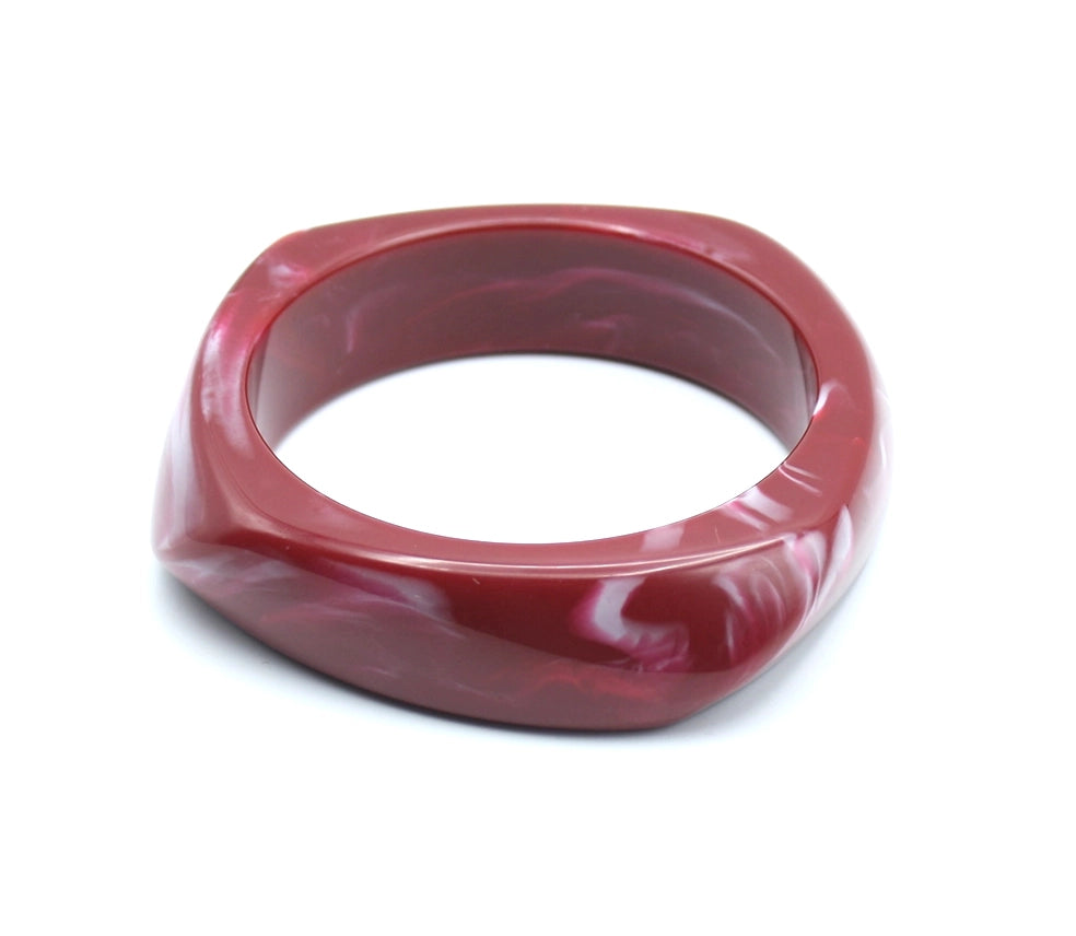 Pulsera Amber en resina burdeos con curvas suaves y textura satinada. - DELACABRA