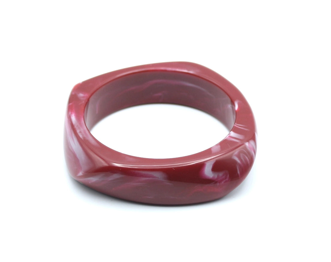 Pulsera Amber de color vino con vetas rosadas y diseño grueso en forma de gota. - DELACABRA