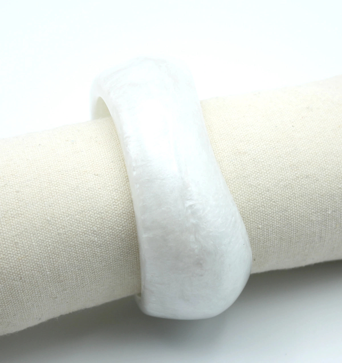 Brazalete Ayre en blanco con textura nacarada sobre base de tela neutra - DELACABRA