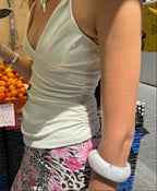 Brazalete blanco Ayre combinado con outfit veraniego en mercado al aire libre - DELACABRA