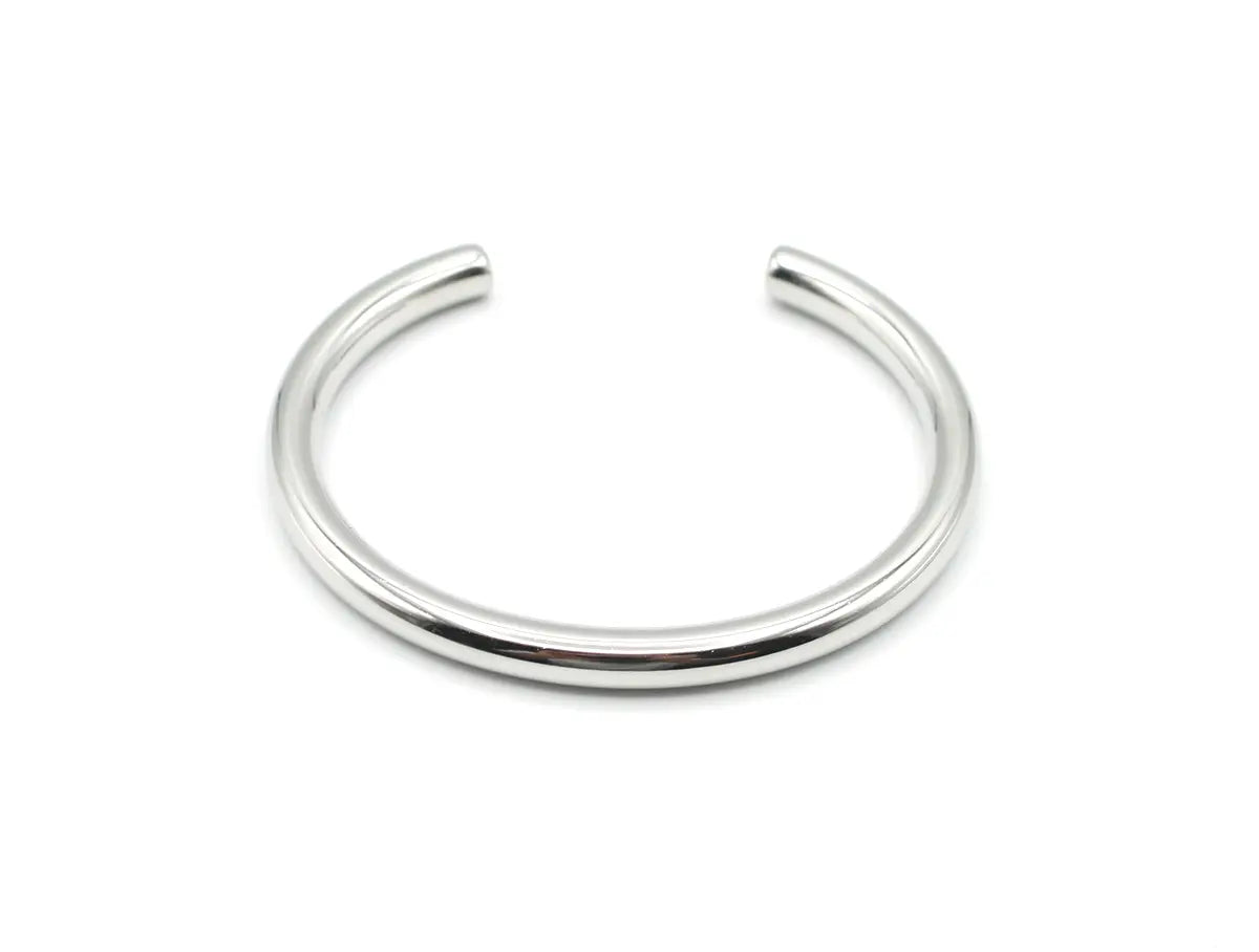 Brazalete plateado Lia de acero inoxidable con diseño de caña rígida y pulido espejo. Joya amable con la piel DELACABRA.