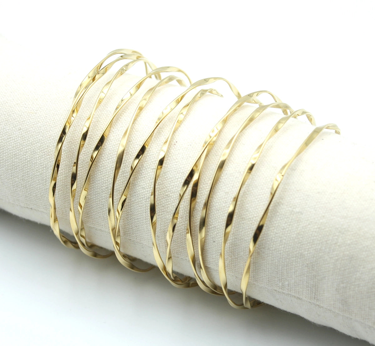 Brazalete Luz dorado con efecto ondulado y acabado brillante sobre soporte neutro - DELACABRA