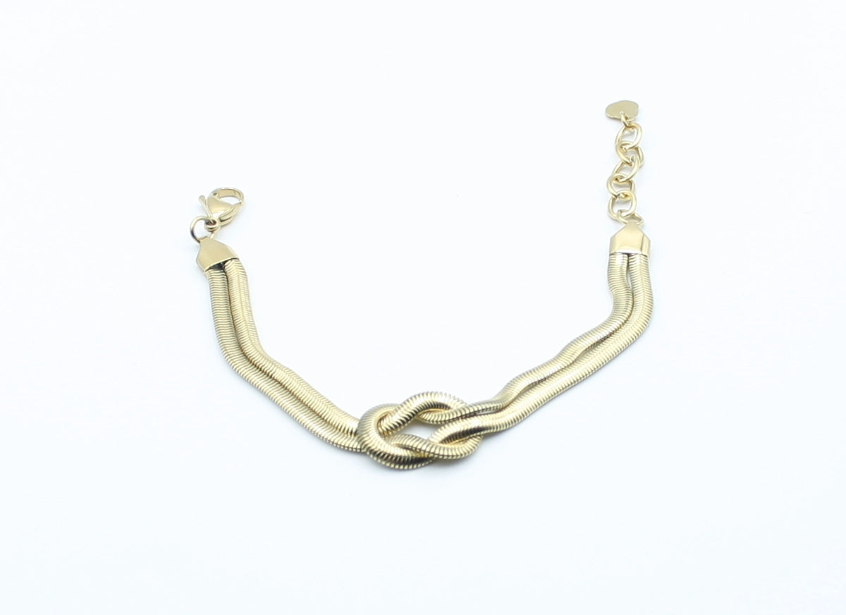Brazalete Tangled acero inoxidable dorado entrelazado simulando un nudo llano, acabado suave y brillante - DELACABRA