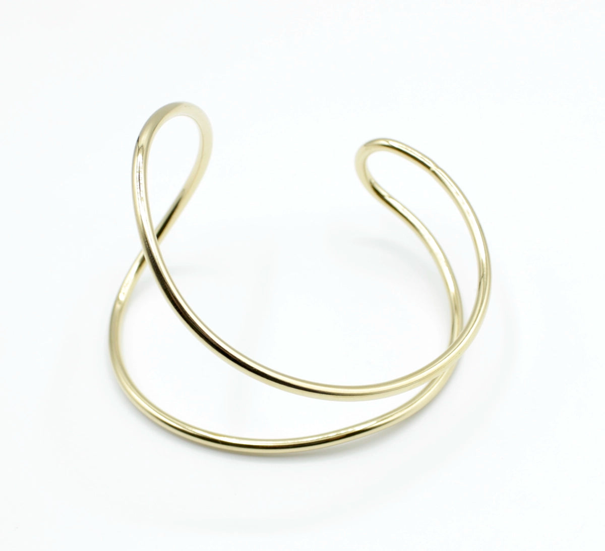 Brazalete Tiana dorado en acero inoxidable, doble aro con curvas enfrentadas estilo abierto, hipoalergénico, resistente al agua, ajustable y duradero -DELACABRA