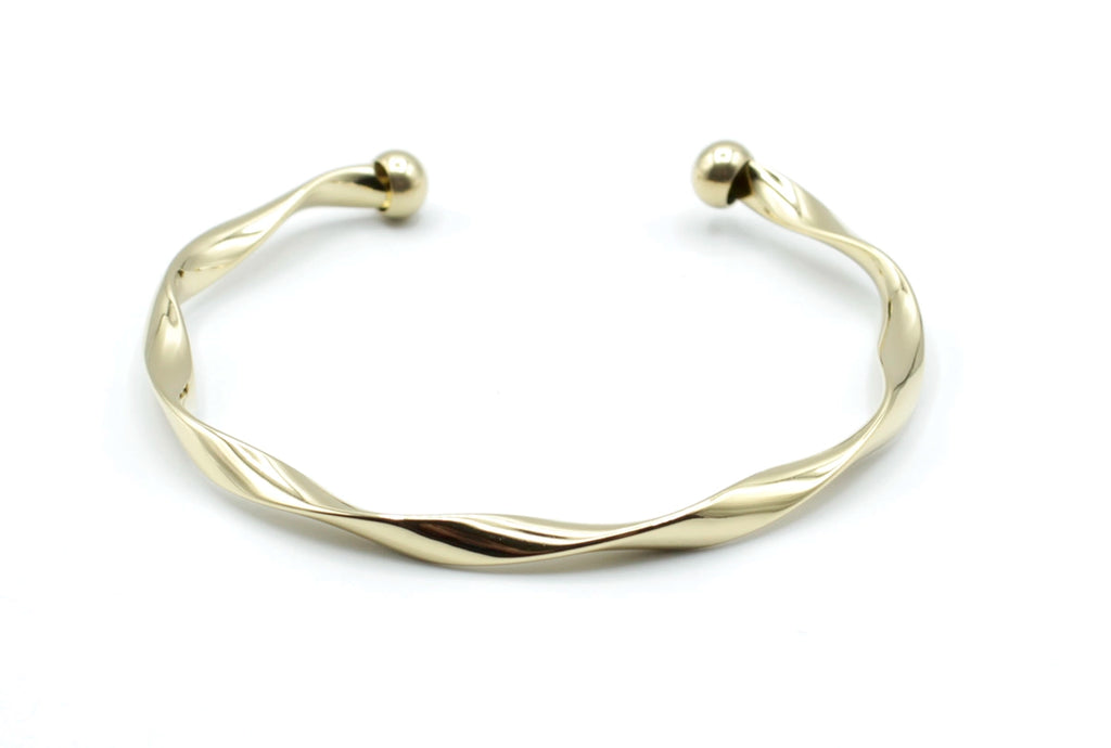 Brazalete Acqua en acero inoxidable dorado con curvatura suave tipo espiral, acabado pulido, hipoalergénico, resistente al agua, ajustable y duradero -DELACABRA