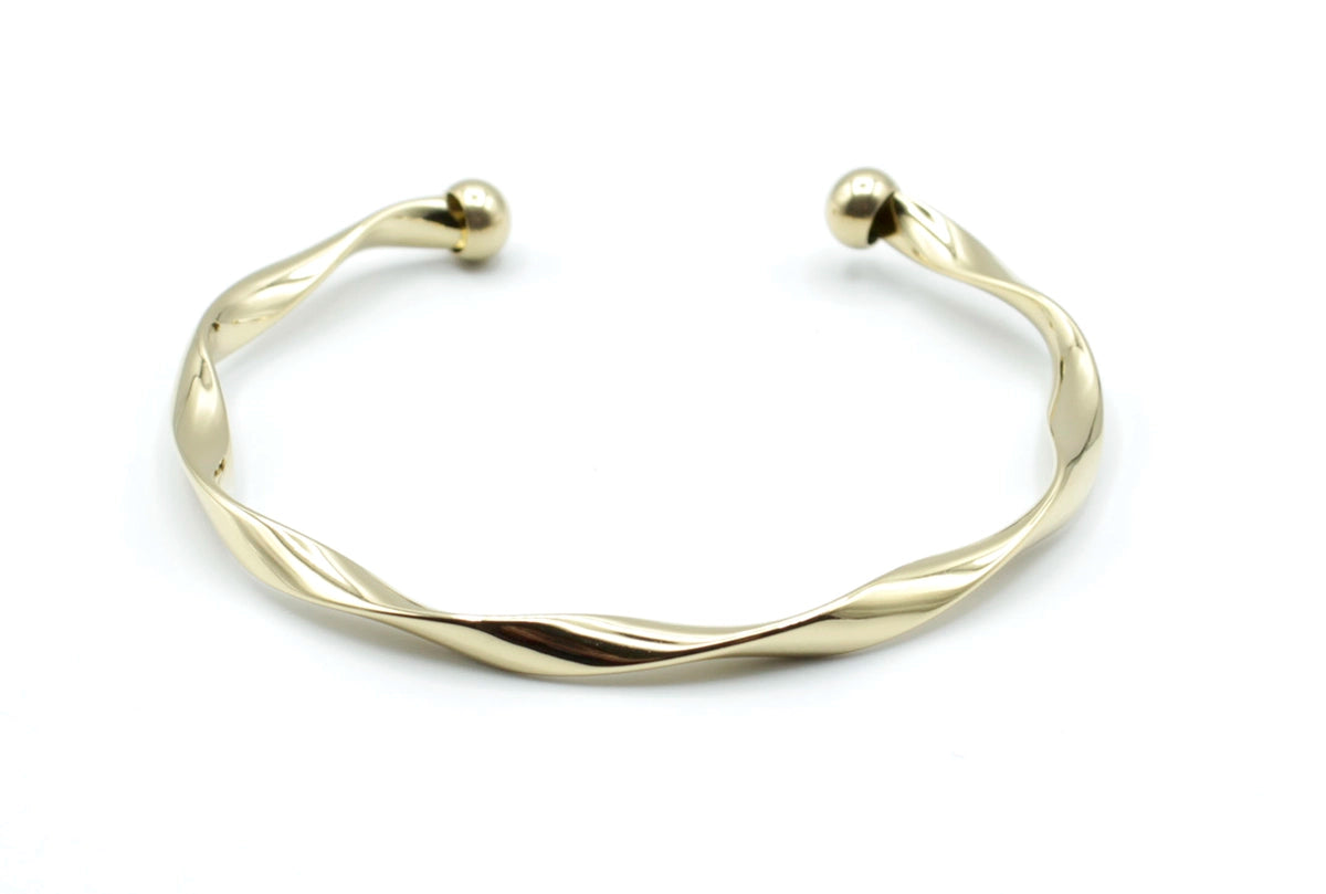 Brazalete Acqua en acero inoxidable dorado con curvatura suave tipo espiral, acabado pulido, hipoalergénico, resistente al agua, ajustable y duradero -DELACABRA