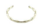 Brazalete dorado diseño bamboo abierto y curvado, fabricado en acero inoxidable, hipoalergénico, resistente al agua, ajustable y duradero -DELACABRA