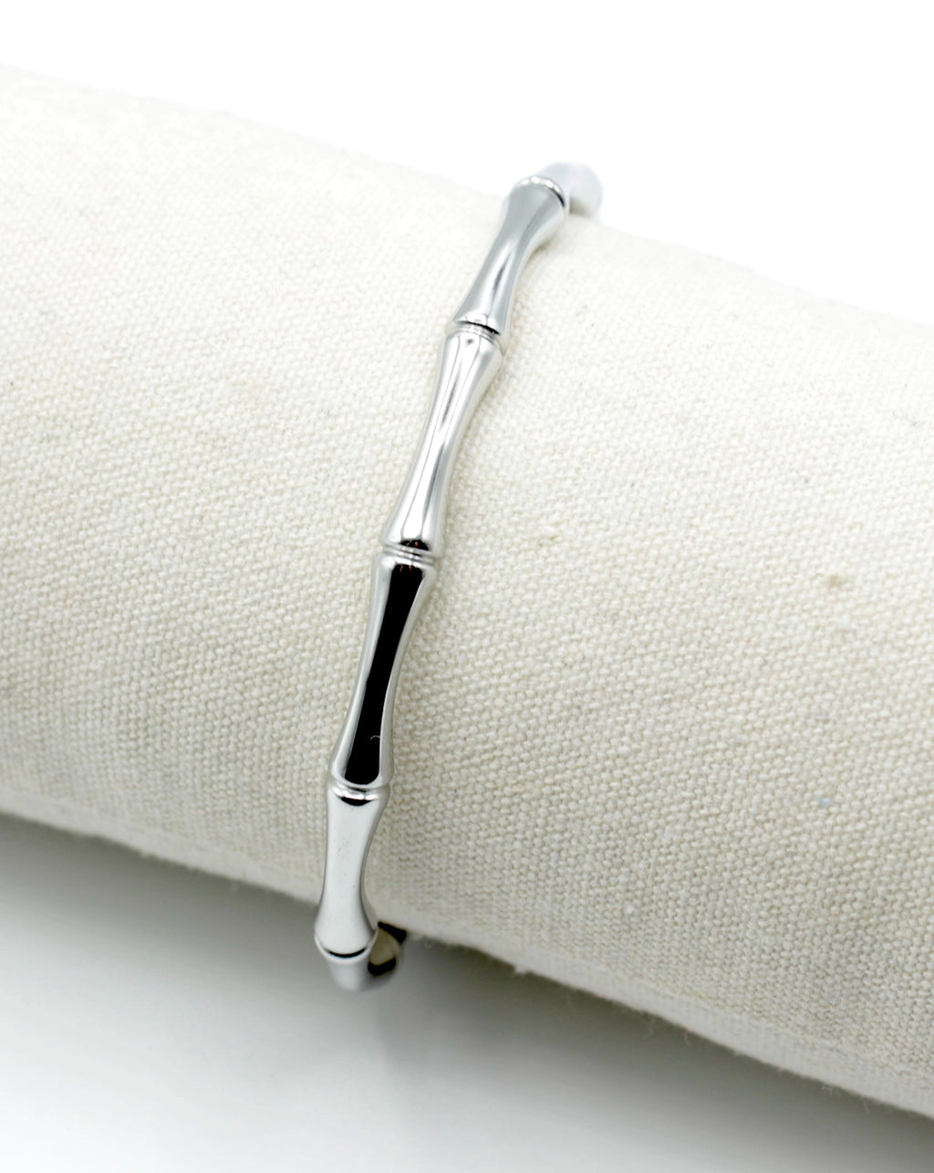 Brazalete de acero inoxidable plateado con diseño inspirado en el bamboo, apoyado sobre cojín textil, hipoalergénico, resistente al agua, ajustable y duradero -DELACABRA
