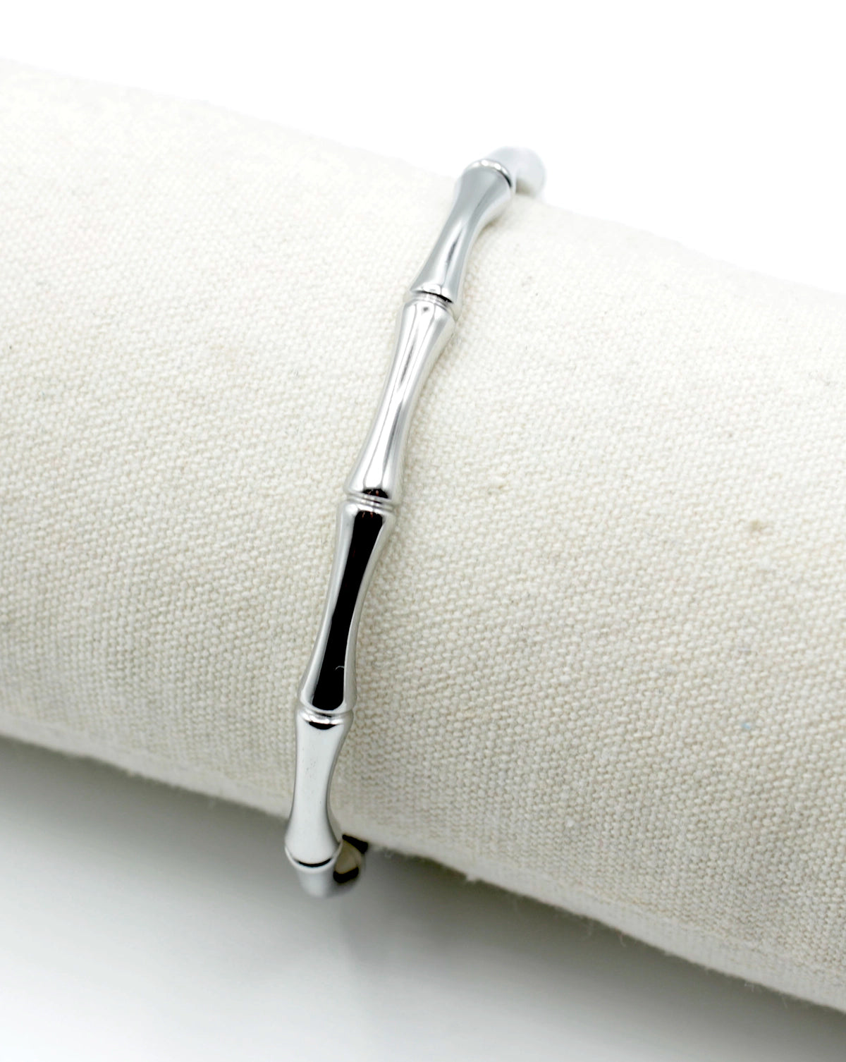 Brazalete de acero inoxidable plateado con diseño inspirado en el bamboo, apoyado sobre cojín textil, hipoalergénico, resistente al agua, ajustable y duradero -DELACABRA