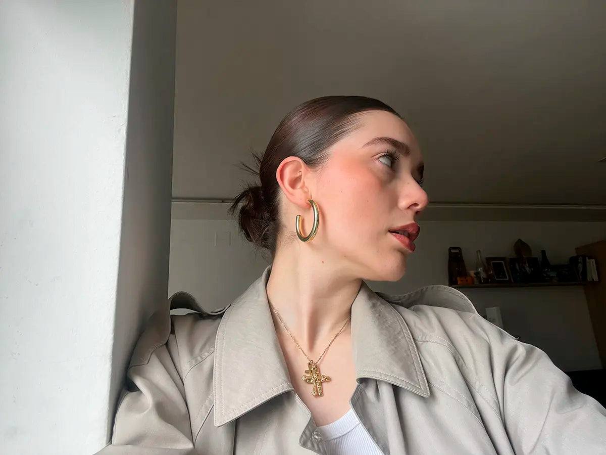 Mujer luciendo pendientes Classic dorados de acero inoxidable, estilo atemporal y sofisticado -DELACABRA