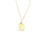 Collar de acero inoxidable dorado con dije rectangular y relieve de rostro artístico.