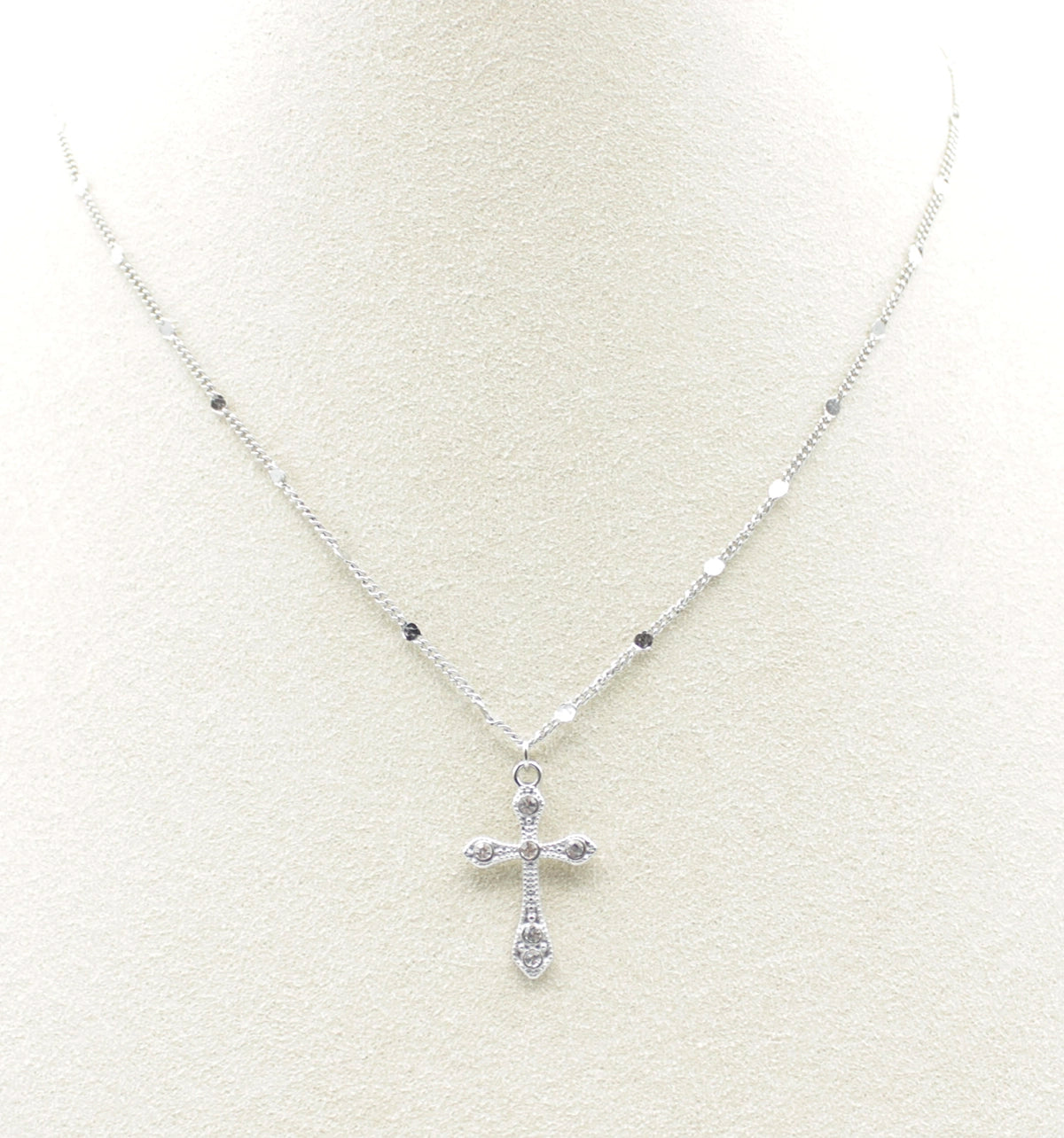 Collar Cross acero inoxidable plateado en busto de tela, cruz labrada y con cinco circonitas blancas que logran un destello y brillo especial en la joya. - DELACABRA