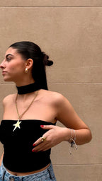 Mujer con collar de estrella grande en acero inoxidable dorado, aro dorado y anillo estrella.
