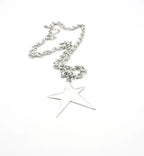 Collar de acero inoxidable plateado con colgante de estrella grande sobre fondo blanco
