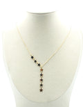 Collar dorado con cadena fina y estrellas colgantes, expuesto sobre busto claro.
